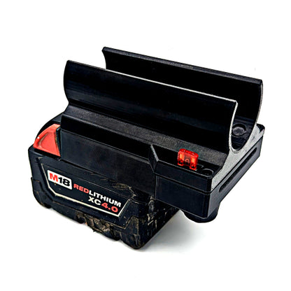 A black M18 red lithium XC-4.0 cordless battery pack with its top cover open, showing a small red indicator light and a black label with white and red text, on a white background.